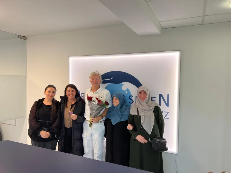 Zufriedene Patientenfamilie mit Blumenstrauß